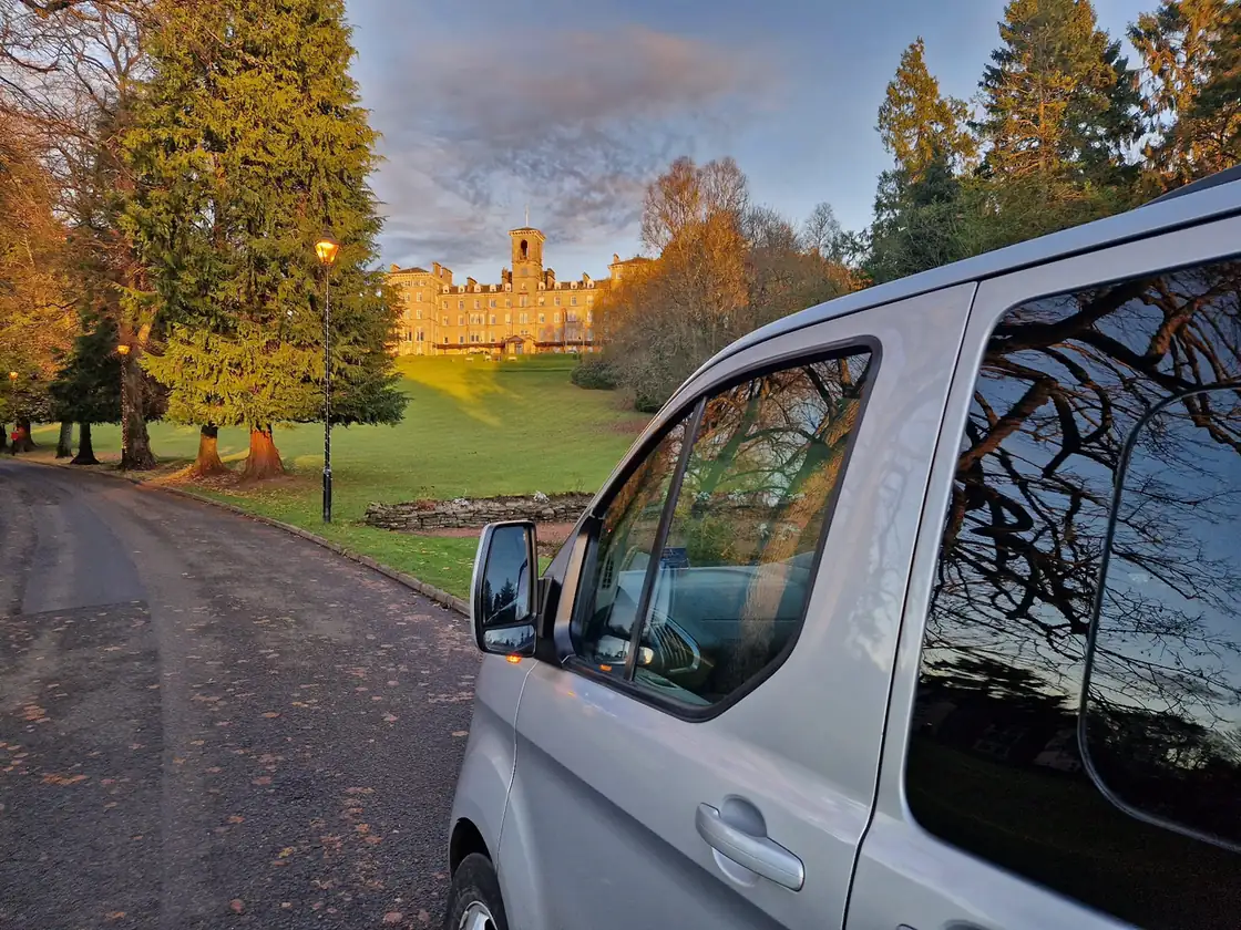 B-Direct minibus beside a loch and wooded hills